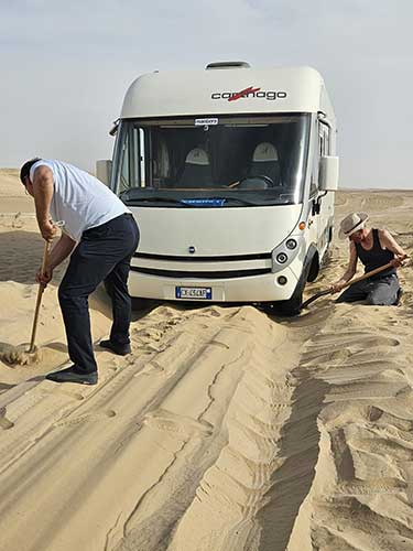 Inconvenienti di viaggio, Aldo che cerca di liberare il Camper dalla sabbia