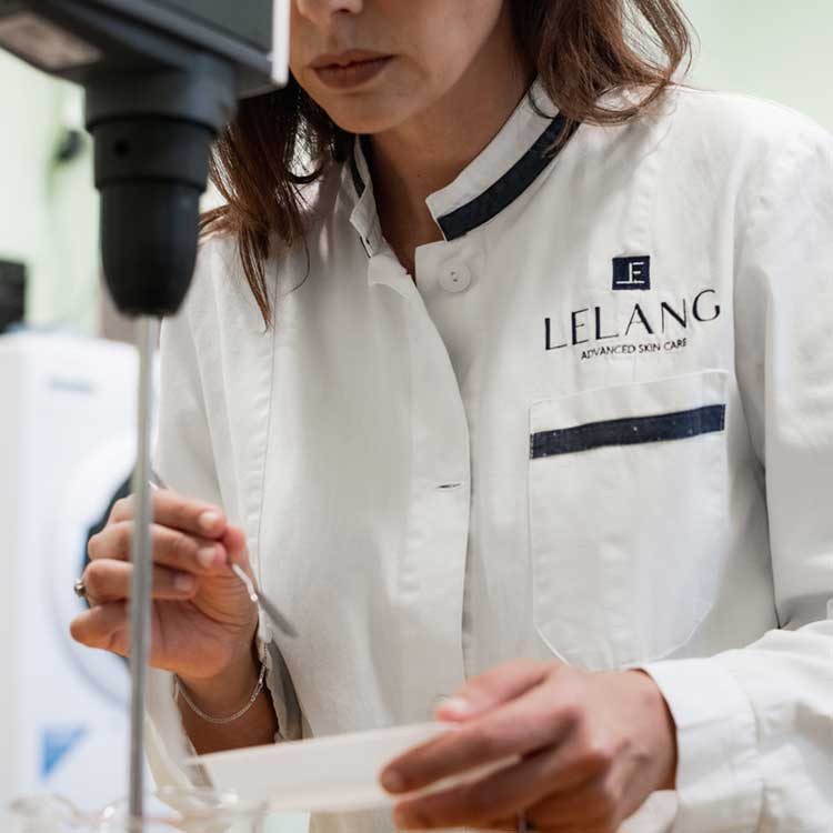 Donna con il camice dove è ricamato il logo di LeLang. Un brand italiano.