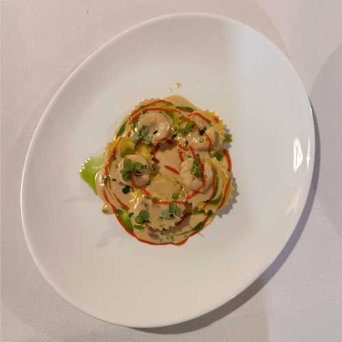 Ravioli ripieni al branzino con pomodorini confit e fumetto affumicato