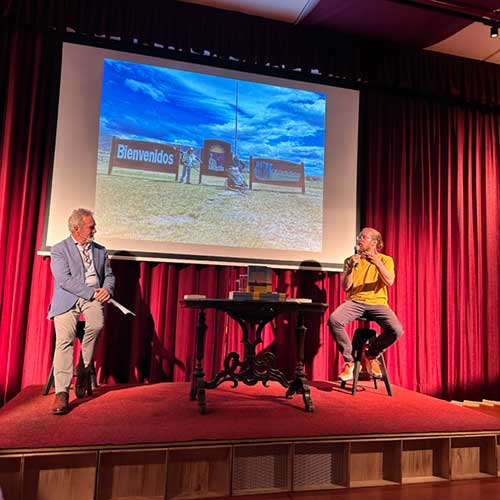 Immagine della serata di presentazione del libro dove Pieroad sta presentando con foto dei suoi viaggi proiettate nello sfondo
